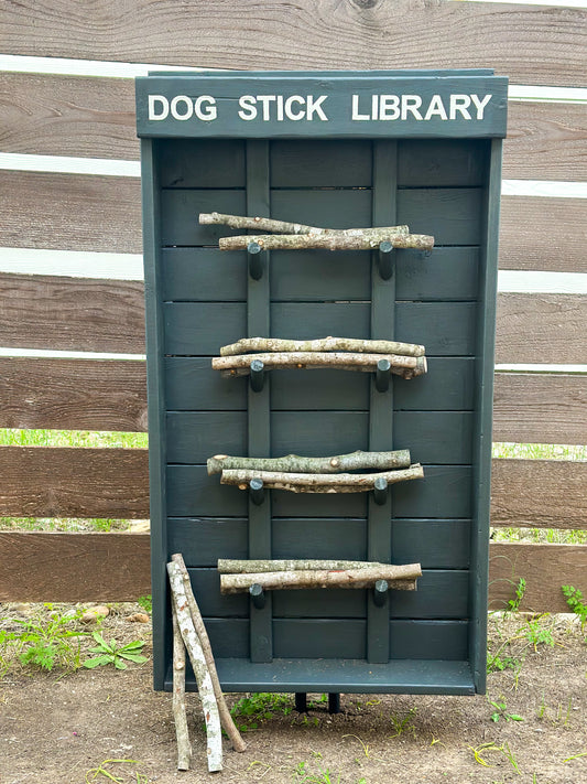 Grey Dog Stick Library mounted on fence with sticks loaded on pegs